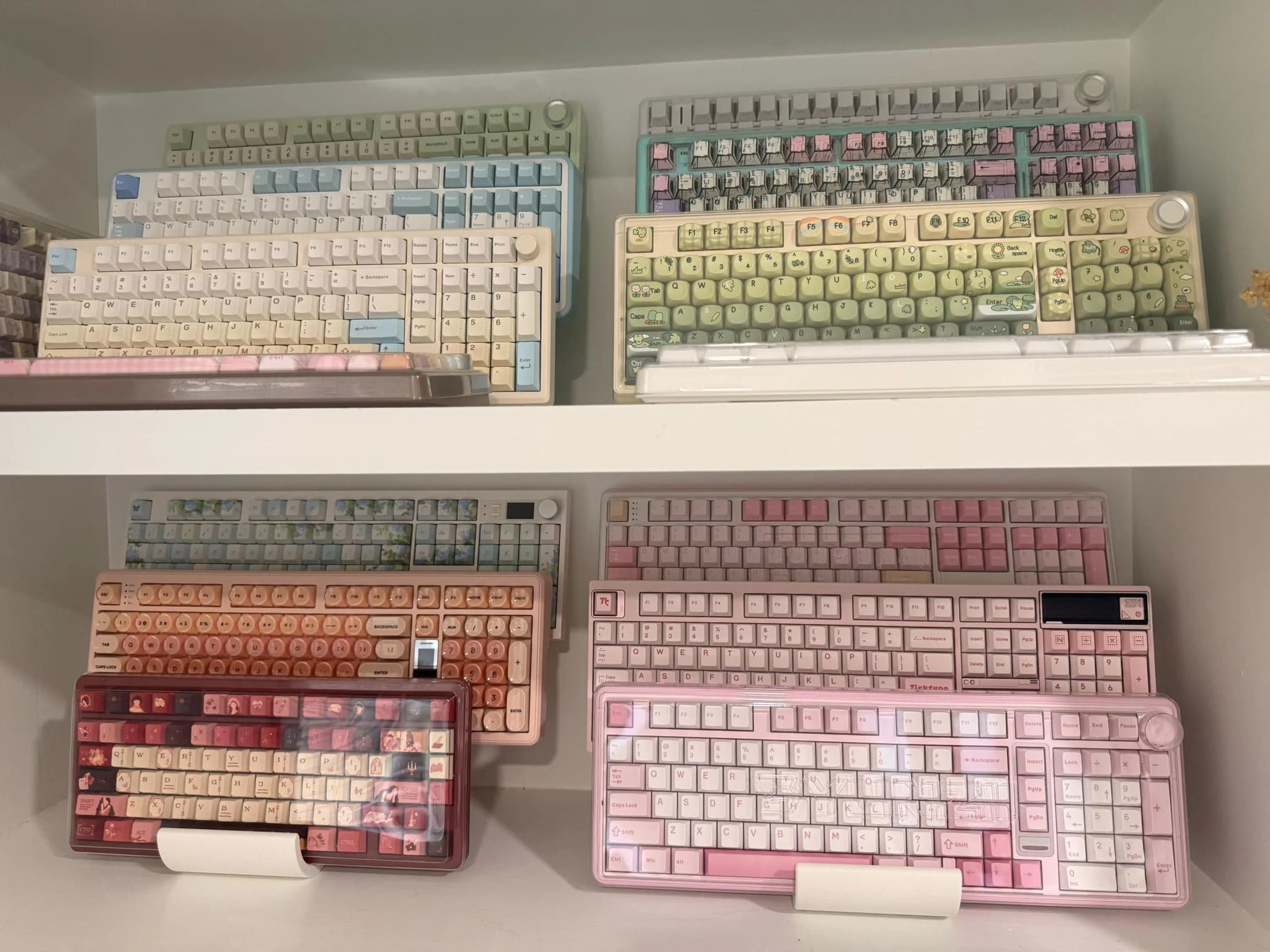 Keyboard collections displayed across four white shelves