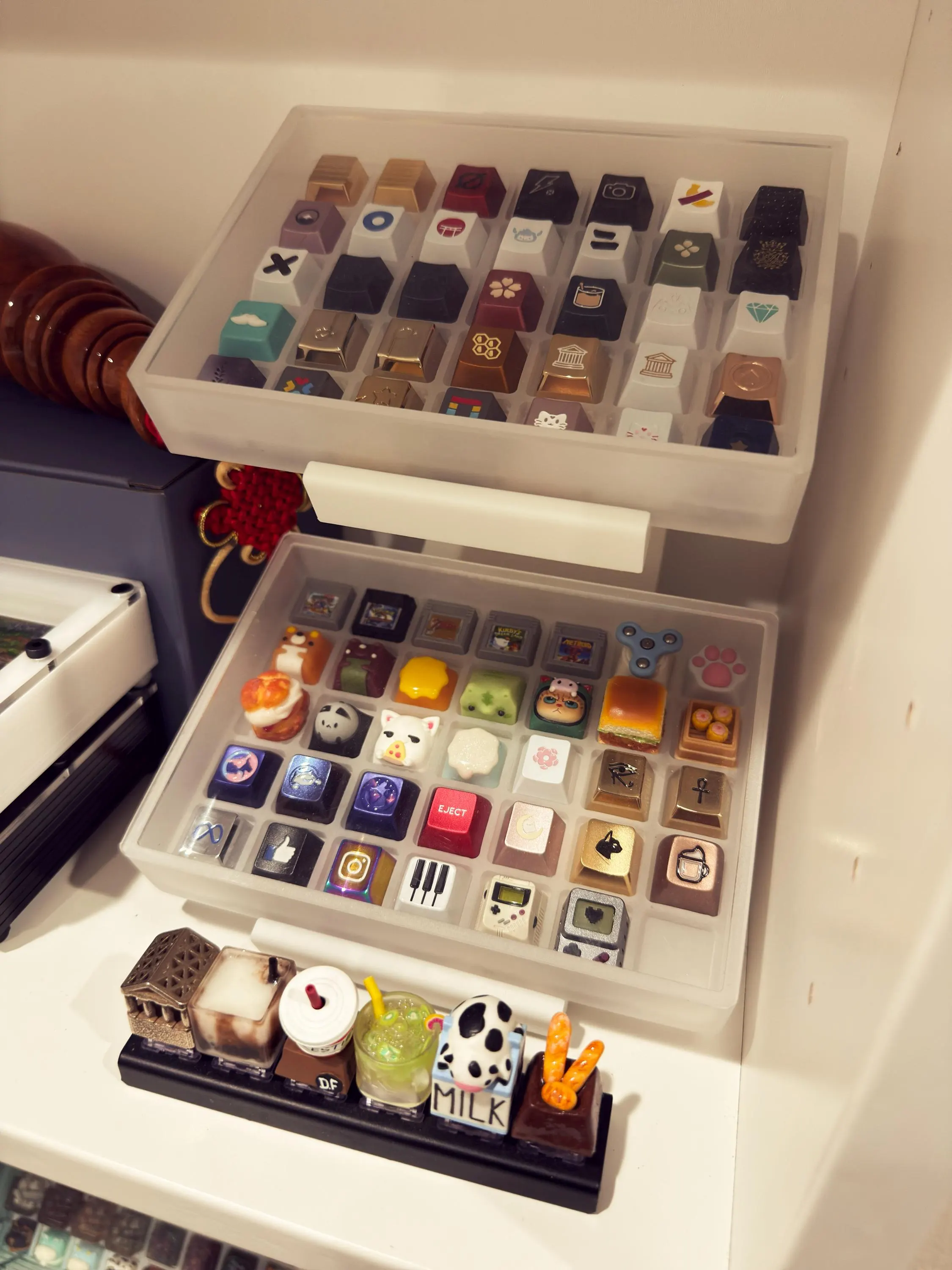 Artisan keycaps in two display cases on a shelf